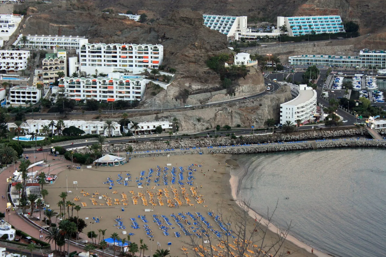 Sunbathers and umbrellas on the beach at Puerto Rico resort, Gran Canaria