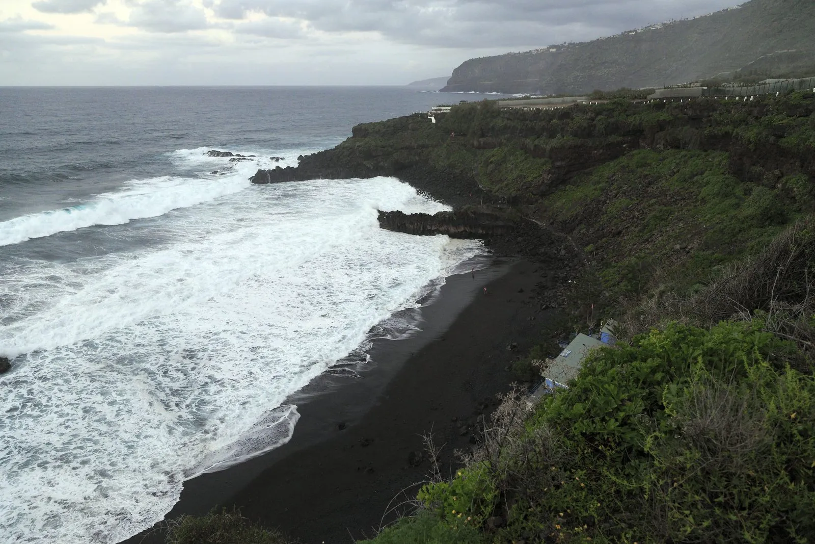 Atlantic surf breaking on the black-sand cove of Playa El Bollullo, northern Tenerife